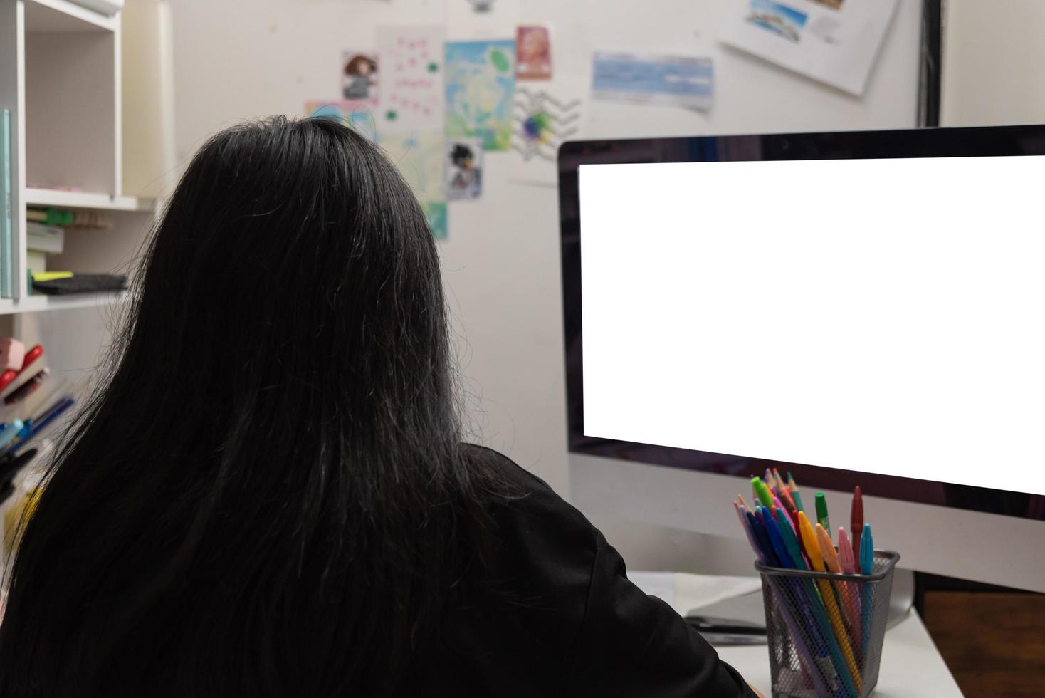 Asian student girl is writing homework and reading book at desk photo