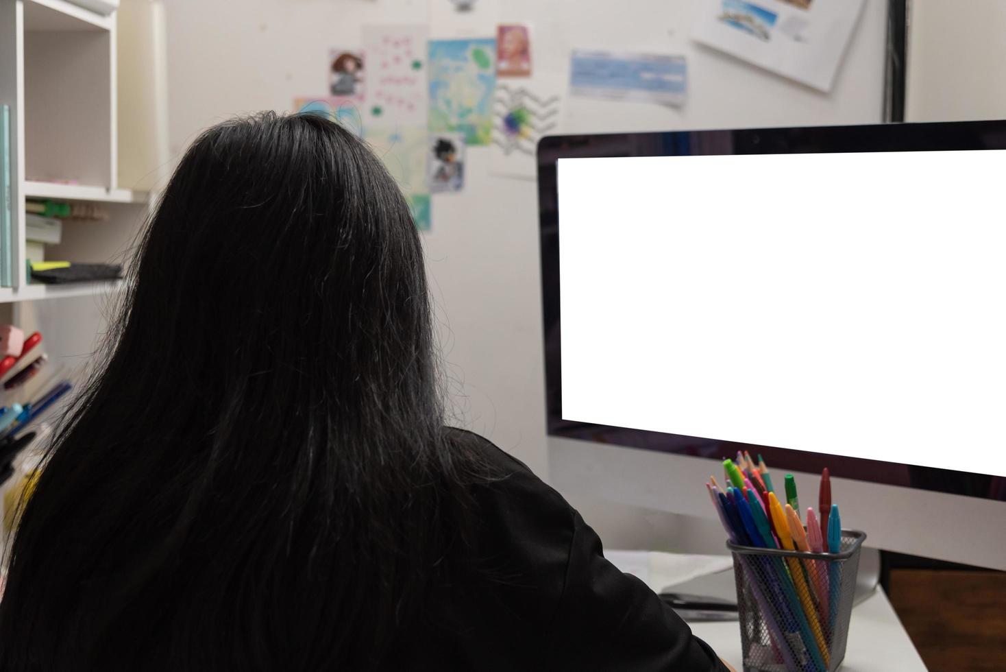 una estudiante asiática está escribiendo deberes y leyendo un libro en el escritorio foto