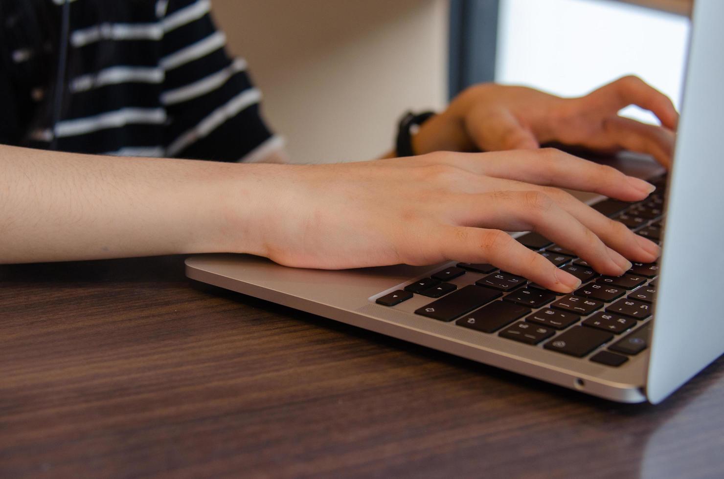 close up hand girl typing keyboard computer laptop digital online network communication internet on table. photo