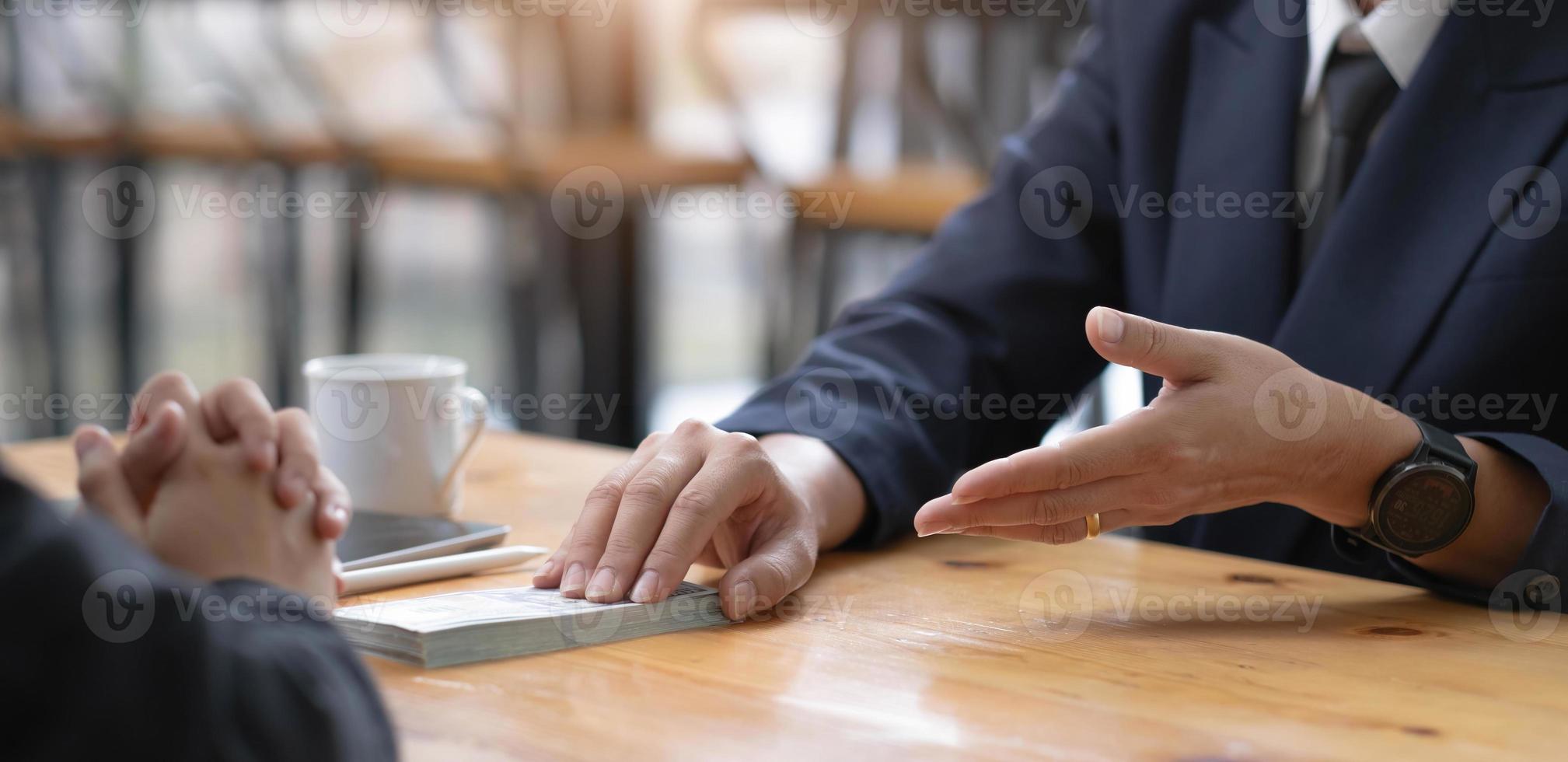 Two businesspeople having a business negotiation meeting in the office, A businessman giving a bribe to his business partner. Cropped and close-up image photo