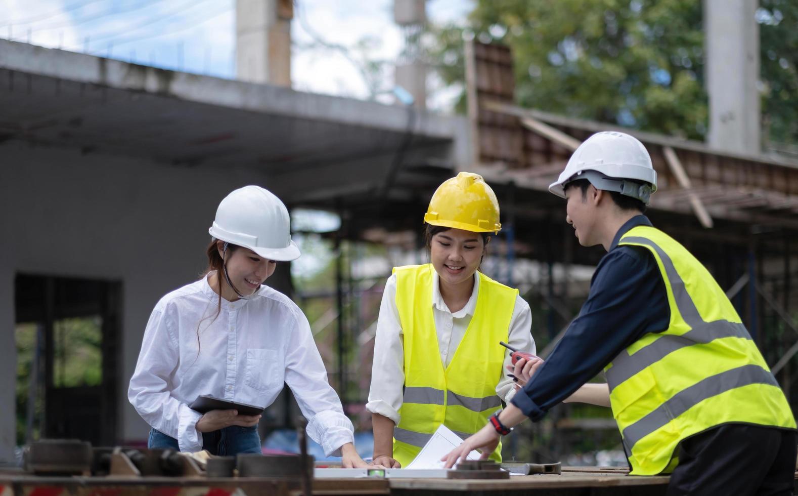 Three experts inspect commercial building construction sites, industrial buildings real estate projects with civil engineers, investors use laptops in background home, concrete formwork framing. photo