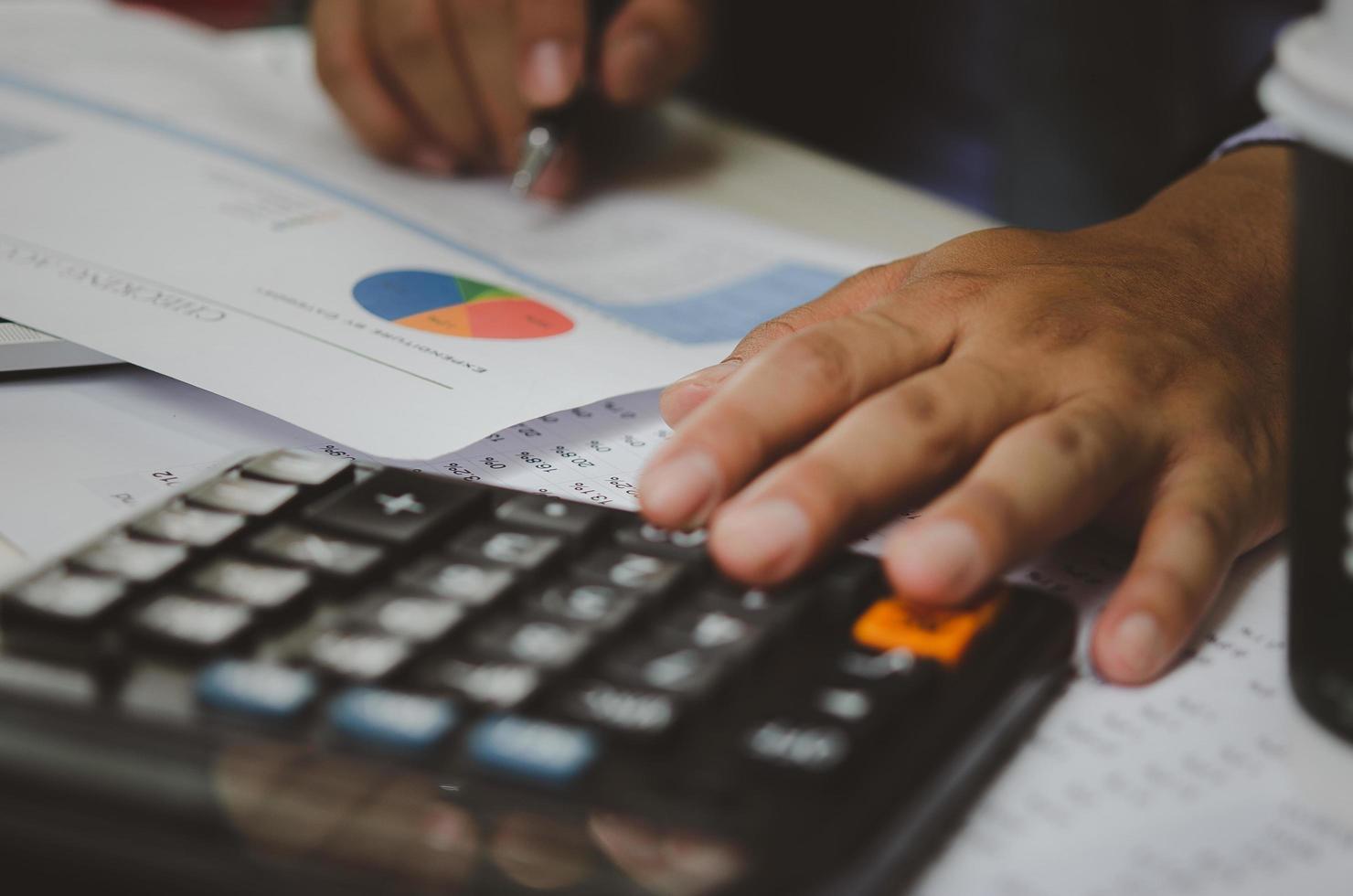 businessman holding calculators and business documents charts statistical data investment analysis and tax accounting. photo