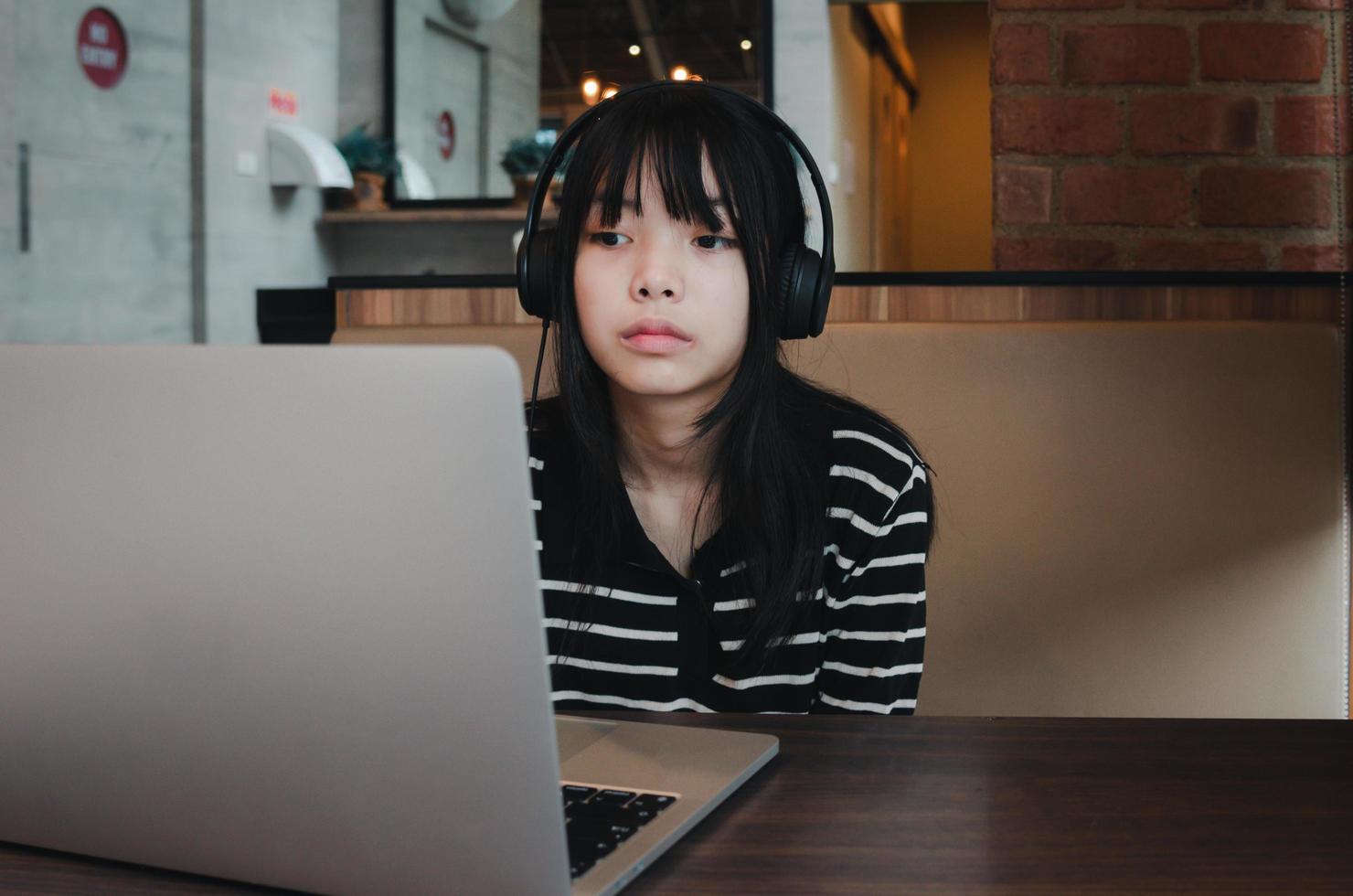 girl using computer laptop watching movie or listen music with earphone and digital internet communication social network. photo