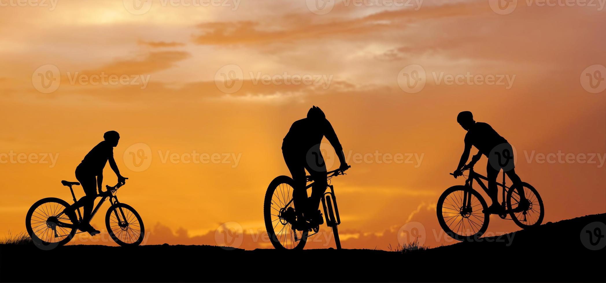 Silhouette of a mountain biker enjoying downhill during the sunset. Mountain bike concept. Mountain bike race - silhouette cyclist on background. photo