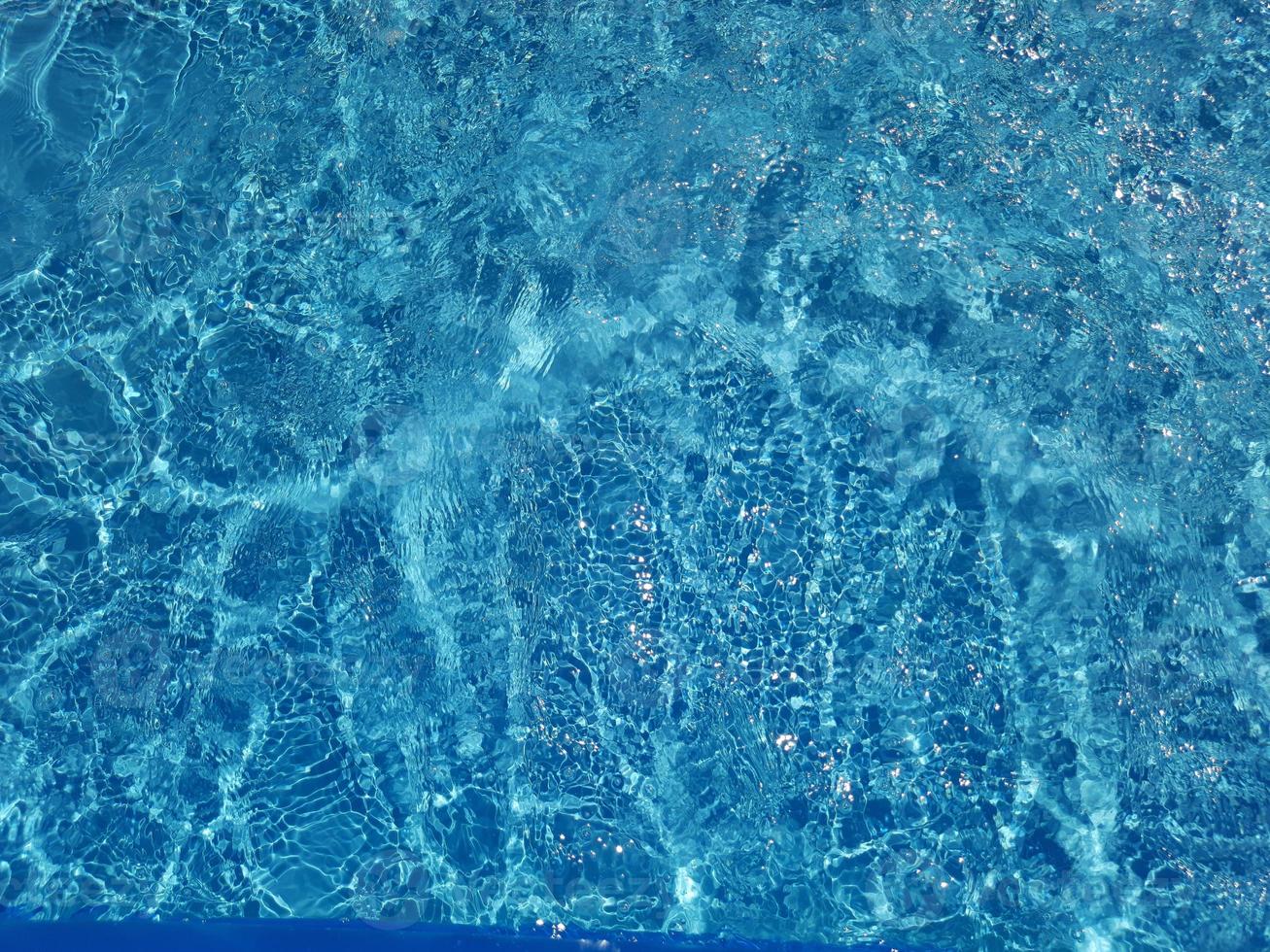 Defocus blurred blue water shining in the sea. rippled water detail background. The water surface in the sea, ocean background. Water wave under sea texture background. photo
