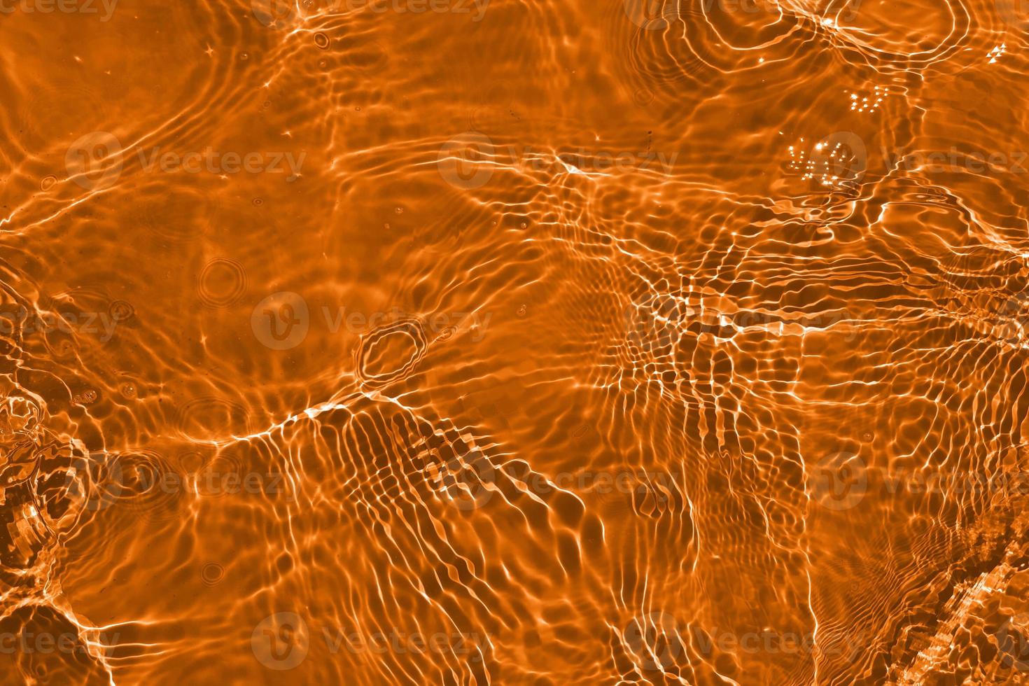 Defocus blurred orange water shining in the sea. rippled water detail background. The water surface in the sea, ocean background. Water wave under sea texture background. photo