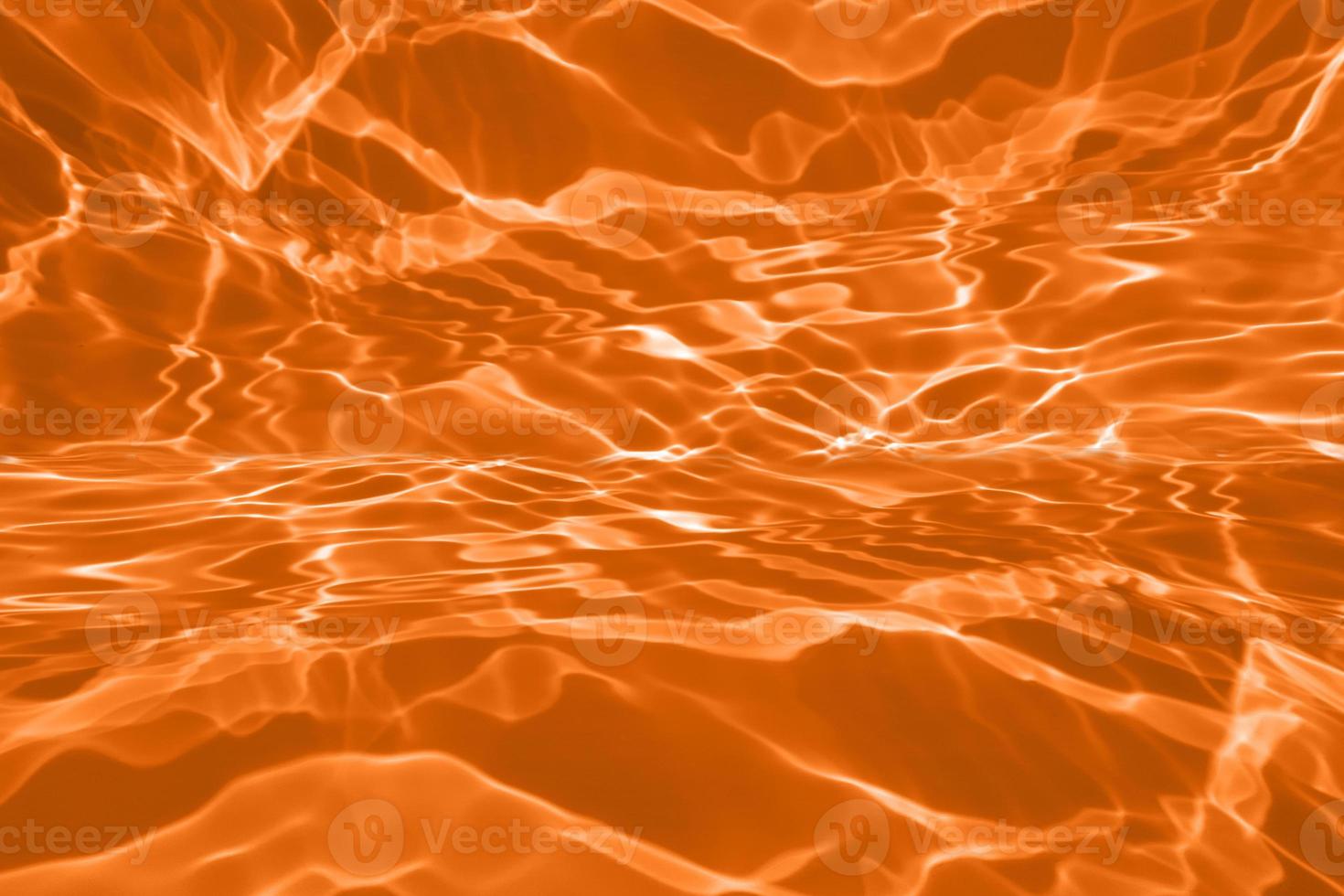 Defocus blurred transparent orange colored clear calm water surface texture with splashes and bubble. Trendy abstract nature background. Water wave in sunlight with copy space. Blue watercolor texture photo