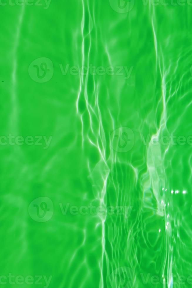 Defocus blurred transparent green colored clear calm water surface texture with splashes and bubble. Trendy abstract nature background. Water wave in sunlight with copy space. Blue watercolor texture photo