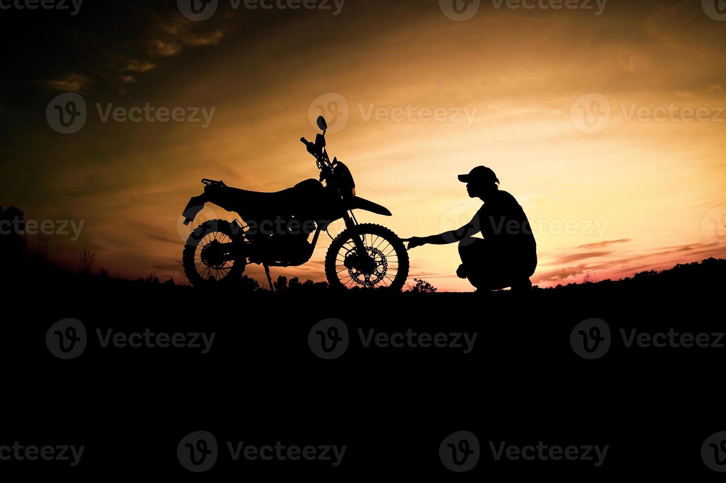 siluetas masculinas y motos de motocross. parque para relajarse en las montañas por la noche. concepto de ocio y viajes de aventura foto