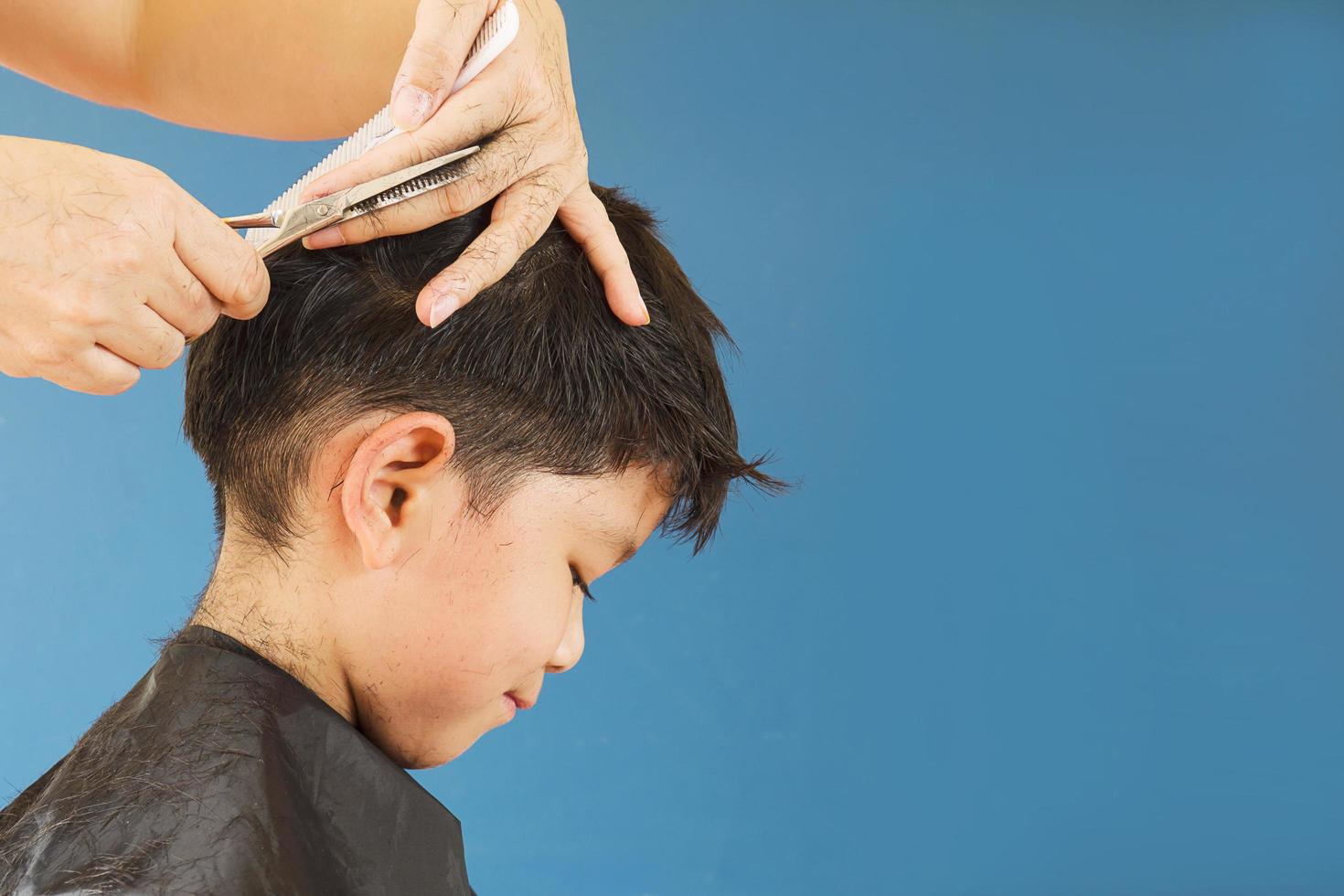 A boy is cut his hair by hair dresser photo