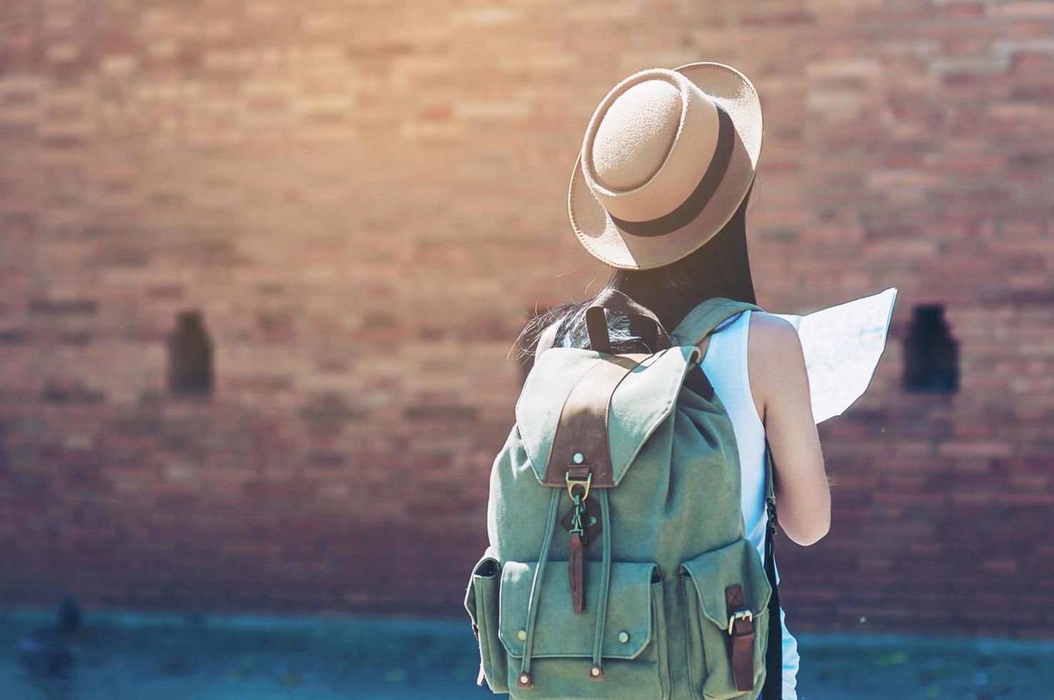 viaje turístico mujer mirando el mapa mientras camina en la estación de tren - concepto de viaje de mochila callejera foto