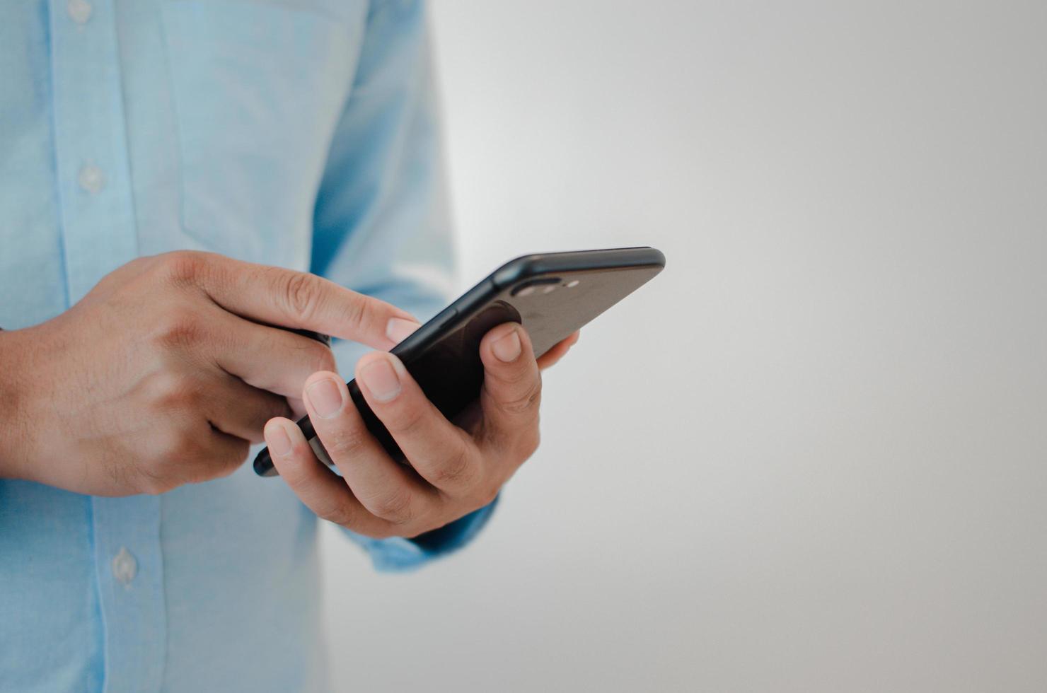 cierre la mano del hombre que sostiene el espacio de copia del teléfono inteligente móvil. persona que envía mensajes de texto concepto de tecnología de Internet. foto