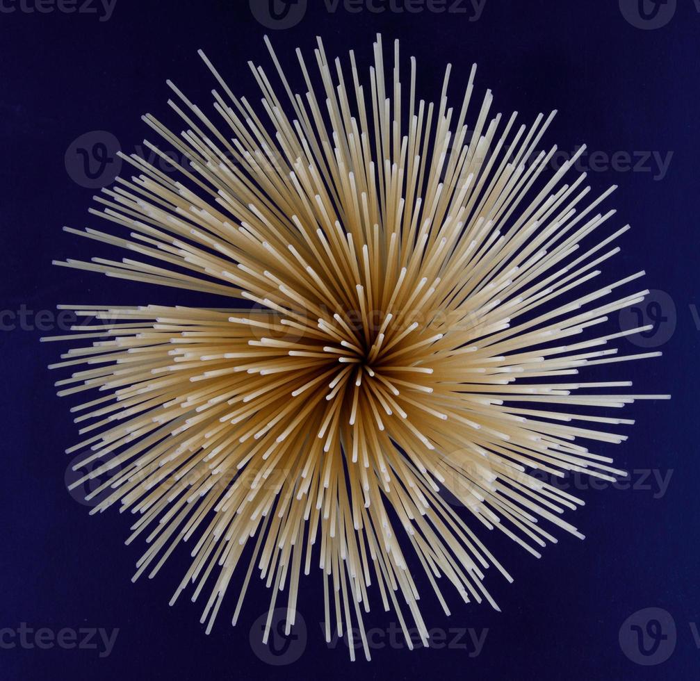 spaghetti removed from the end form a beautiful background. spaghetti fan. The bundle of spaghetti is beautifully laid out in the form of a circle. photo