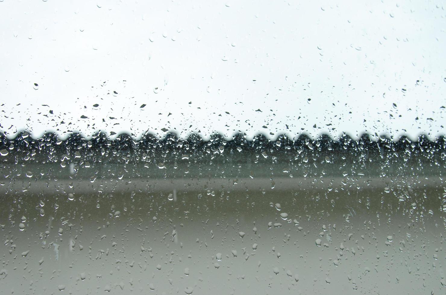 gotas de lluvia en la ventana del fondo de la casa foto