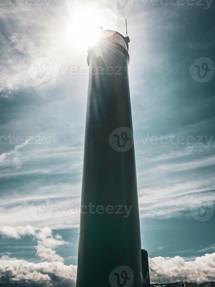 faro bajo la dura luz del sol y el cielo nublado turquesa en ostende, bélgica. foto