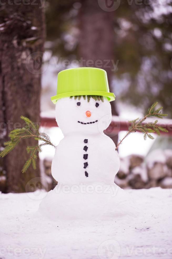muñeco de nieve sonriente con sombrero verde foto