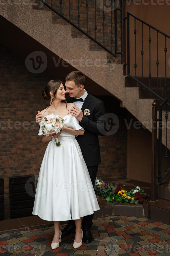 young couple bride and groom in a white short dress photo