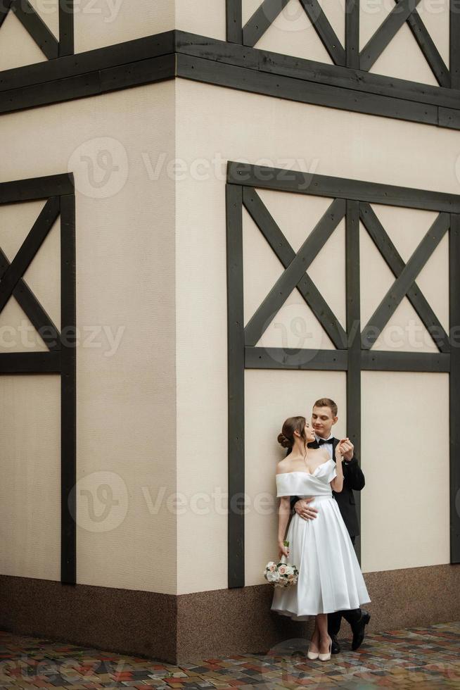 young couple bride and groom in a white short dress photo