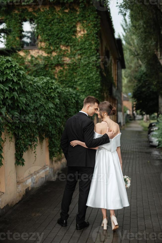 young couple bride and groom in a white short dress photo