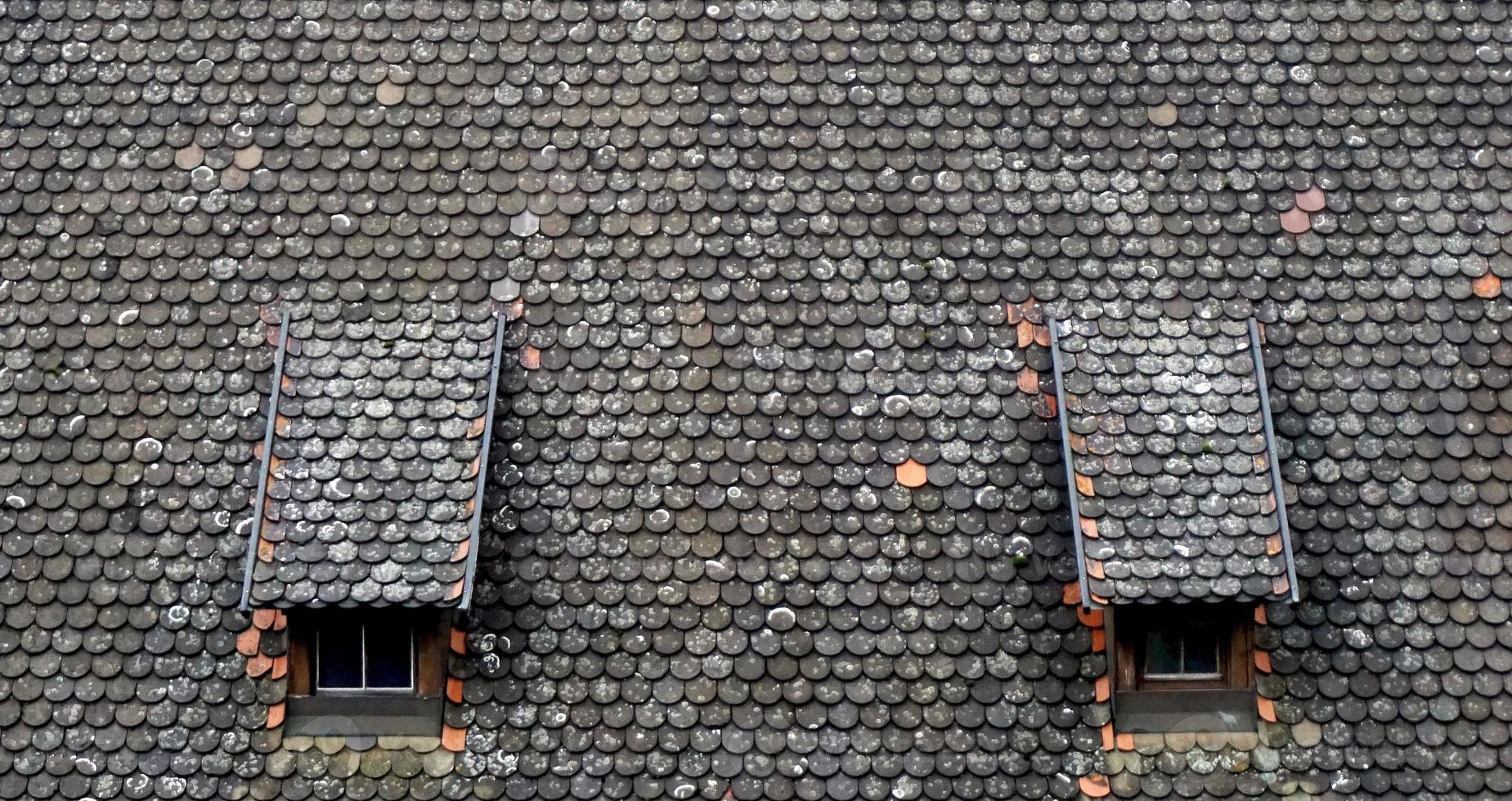 brown old ceramic tile roof top shingles middle ages with two window texture background photo