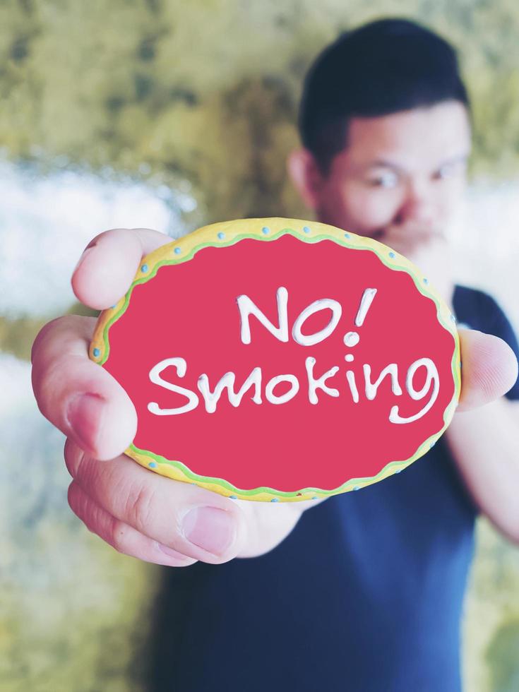 Young man is showing no smoking label photo