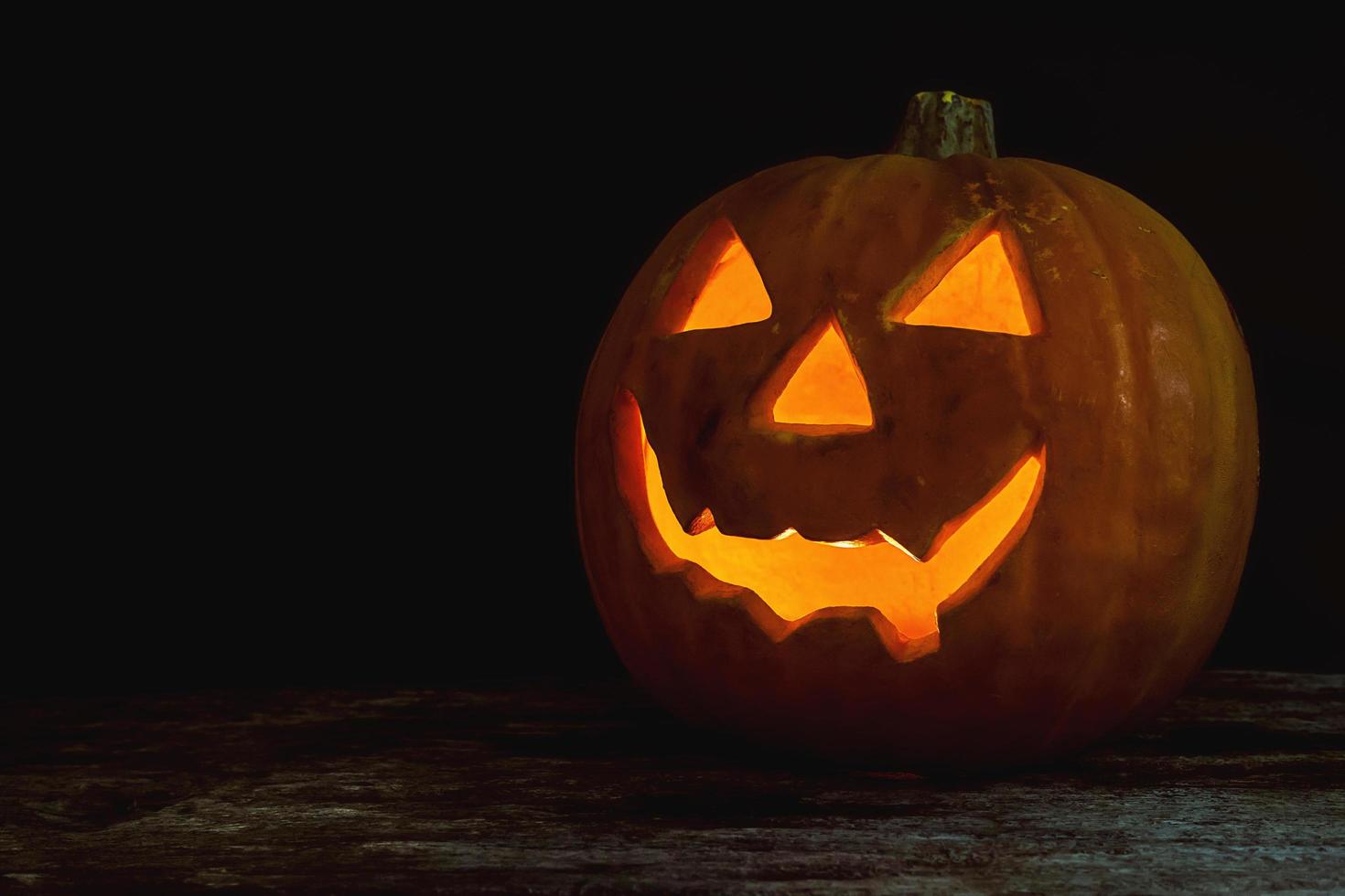 Halloween pumpkin head jack lantern on wooden background photo