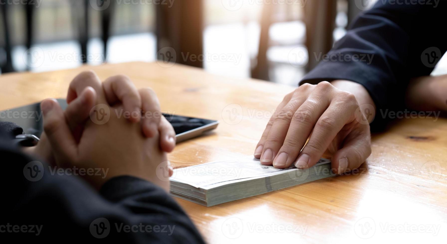 Two businesspeople having a business negotiation meeting in the office, A businessman giving a bribe to his business partner. Cropped and close-up image photo