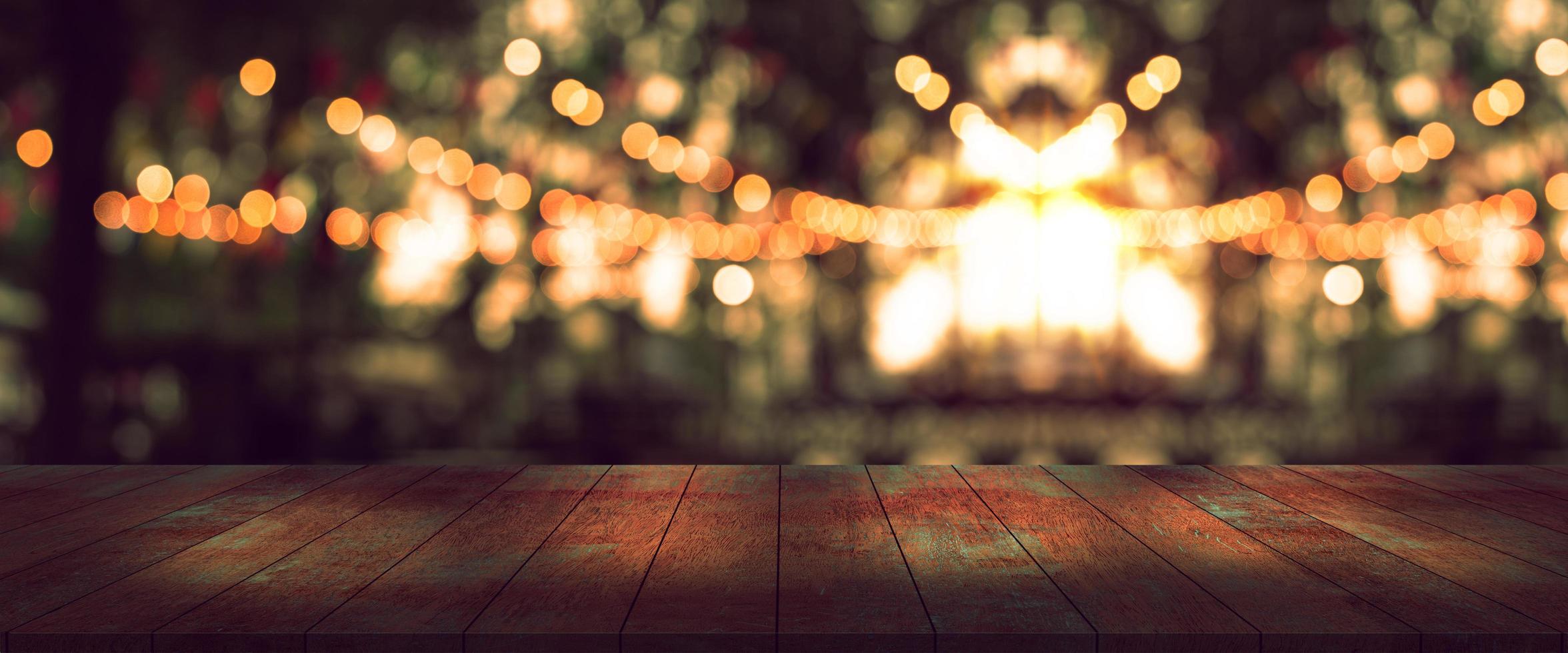top desk with blur party or restaurant  background,long wooden table and blurred bokeh of night street background photo