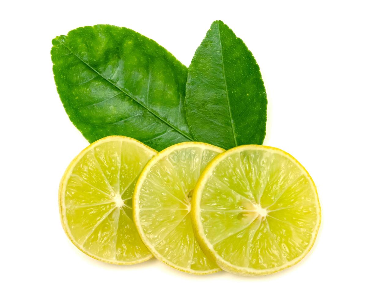 Yellow lemon slice and leaves isolated on white background photo