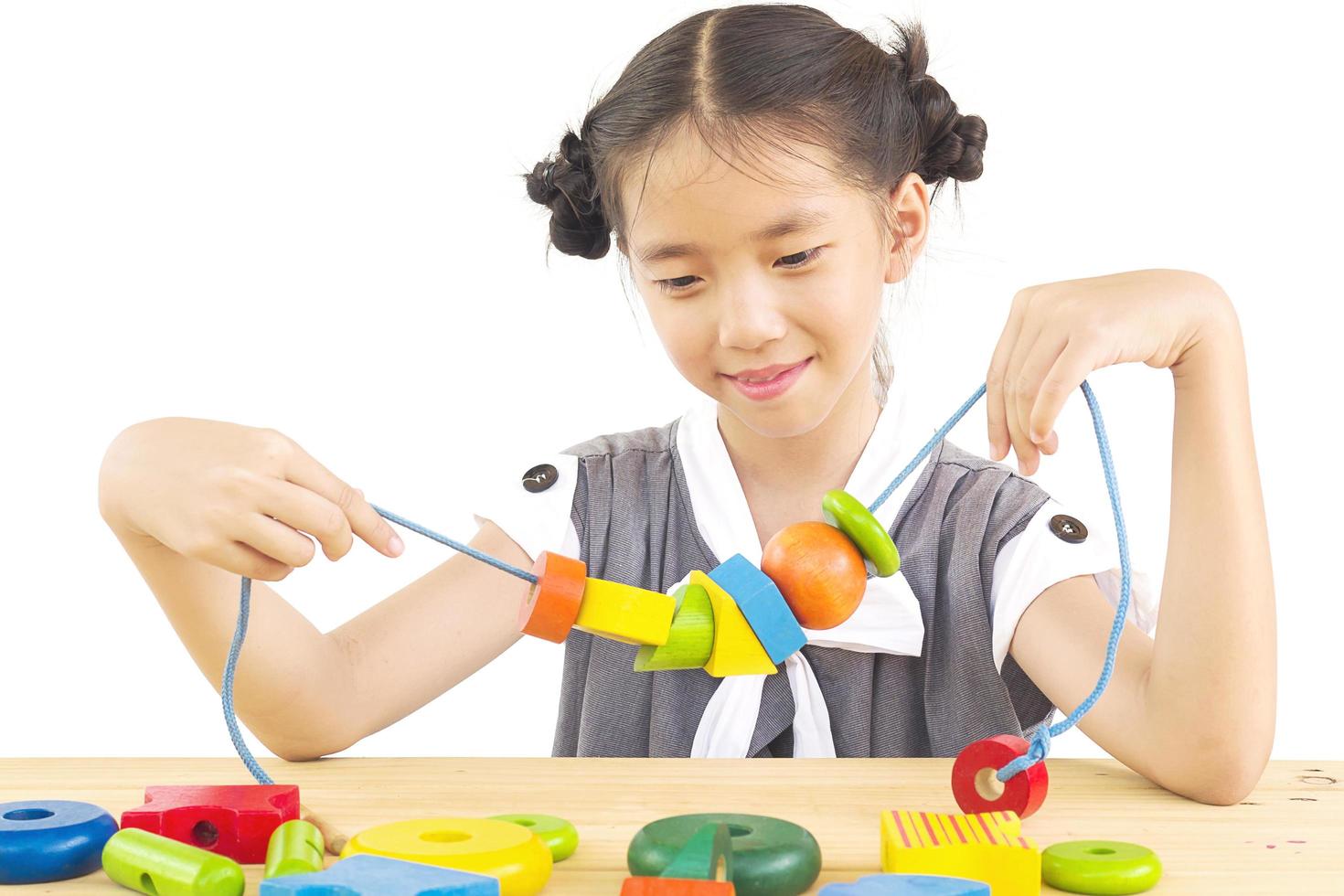 Lovely asian girl is play colorful wood block toy photo