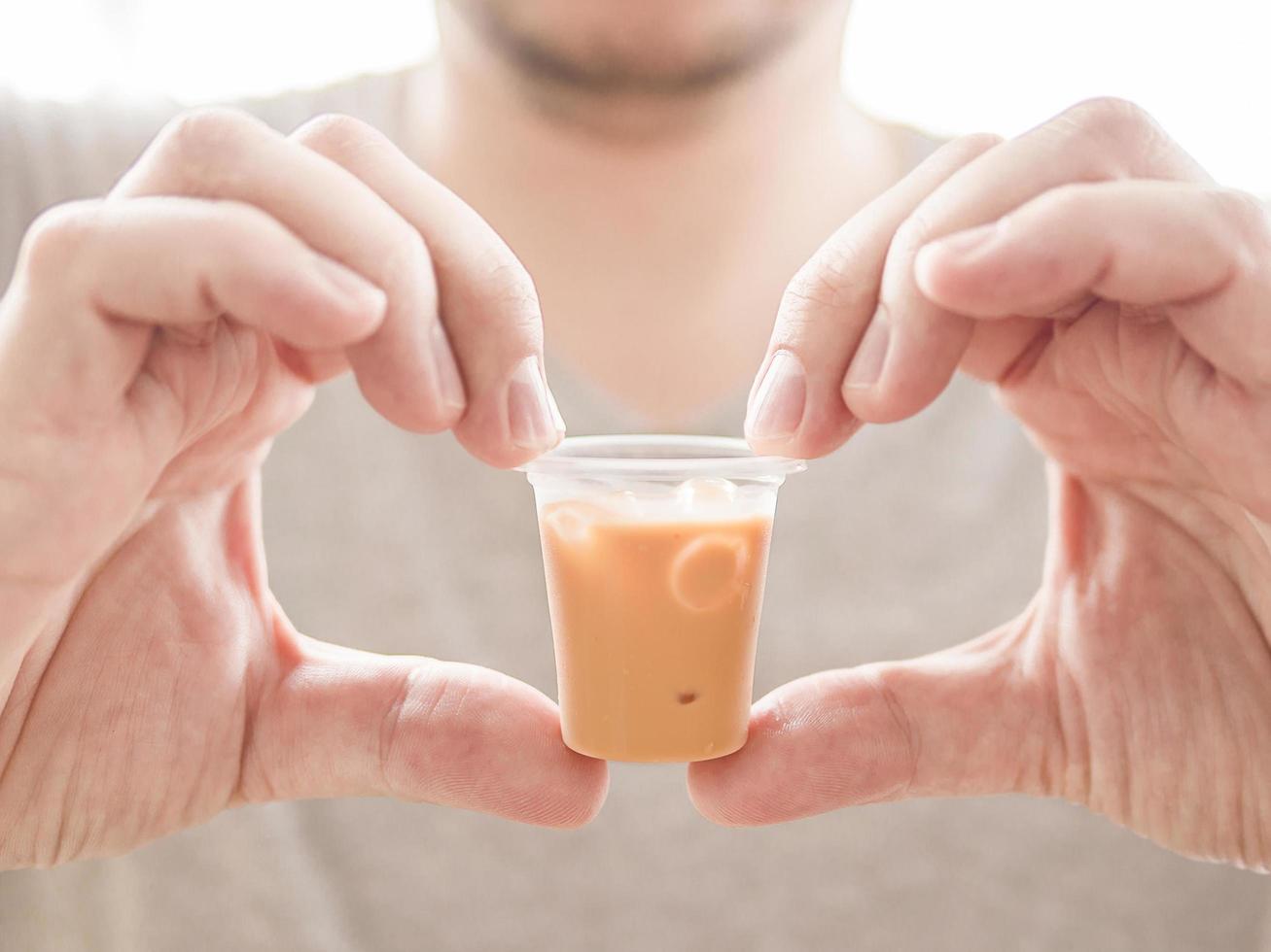 Man showing small glass of ice tea photo