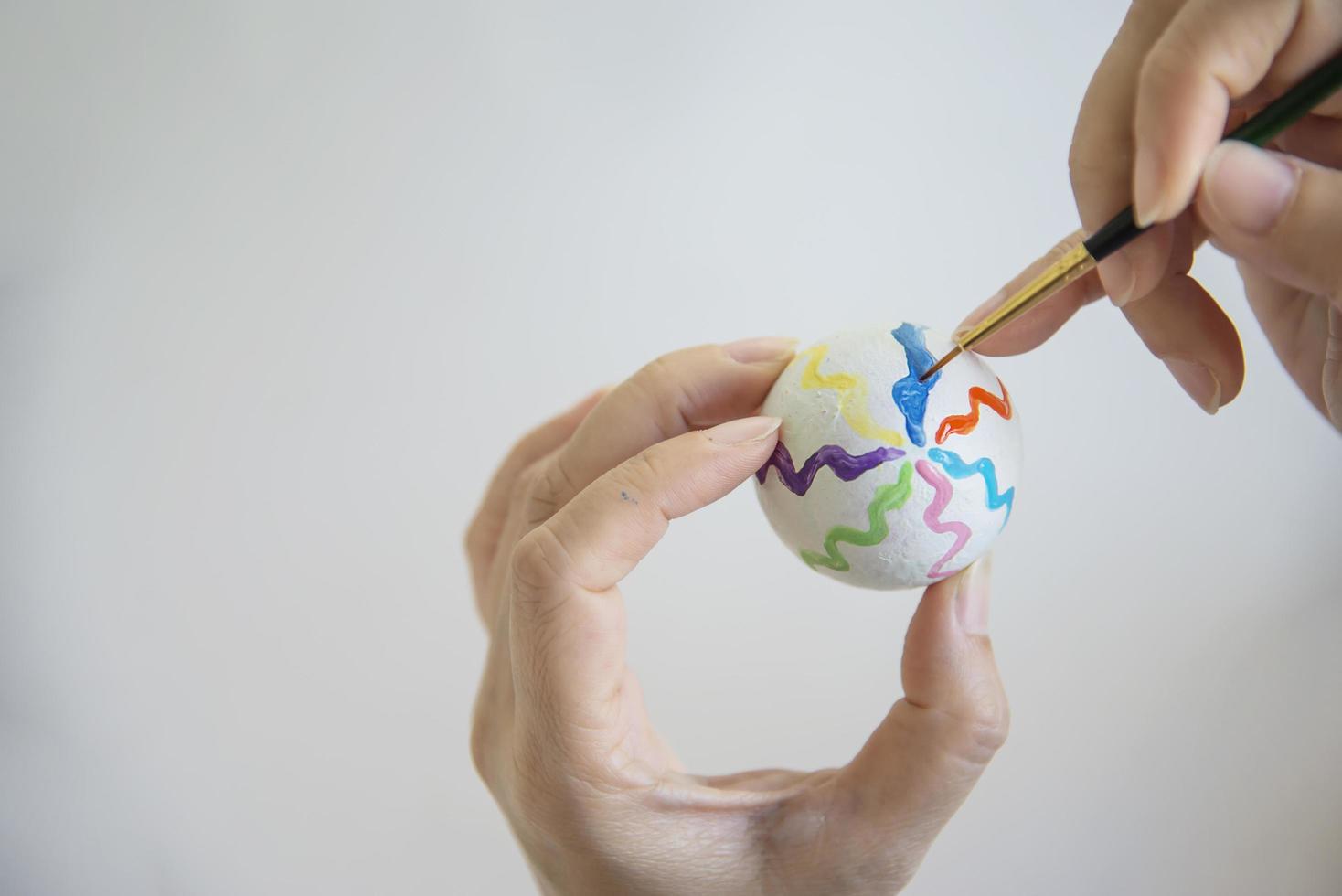 gente pintando coloridos huevos de pascua - concepto de celebración de vacaciones de pascua foto