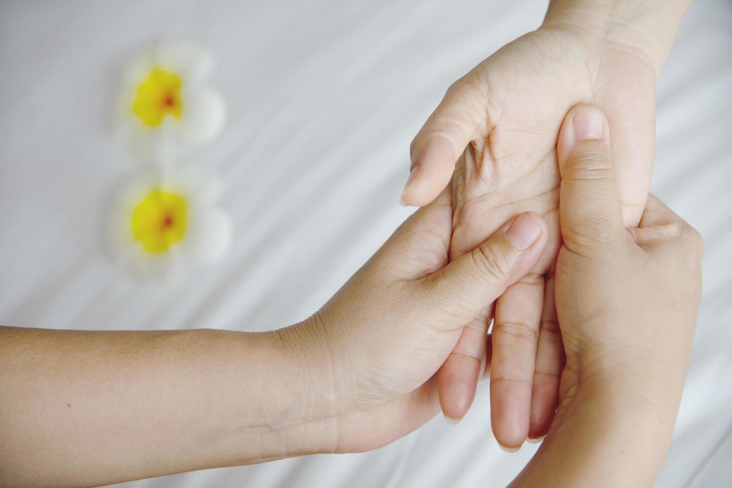 Hand spa massage over clean white bed background - people relax with hand massage service photo