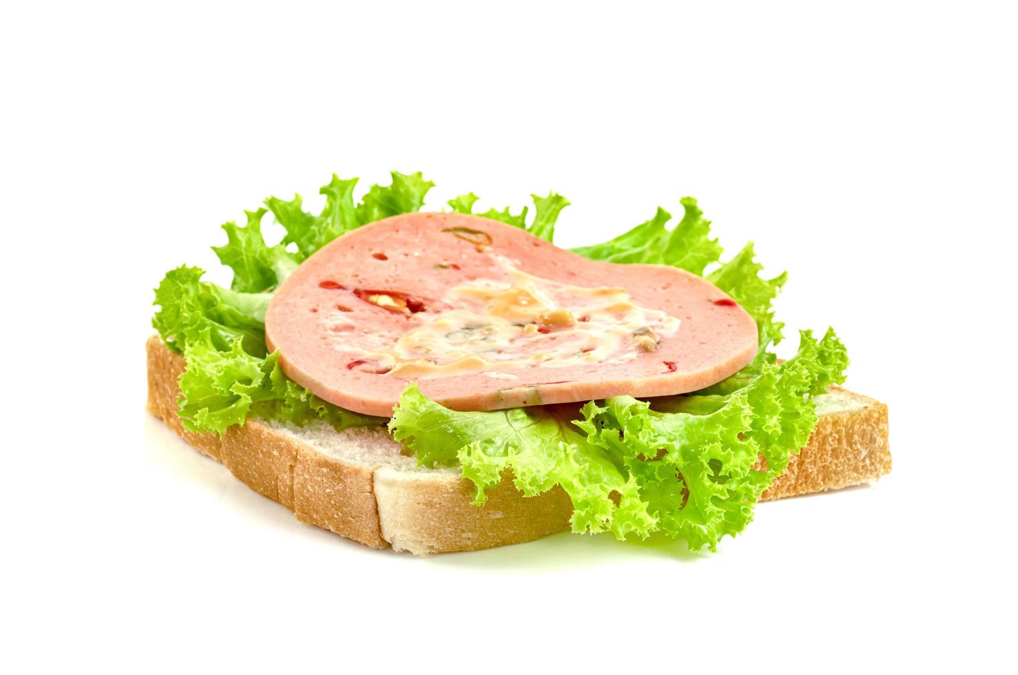 bologna sliced with bread and lettuce leaf isolated on white background photo