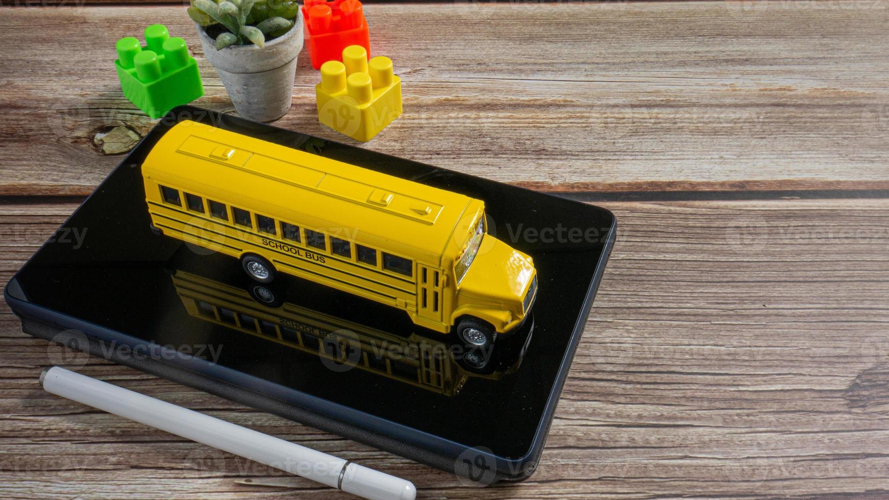 autobús escolar en tableta para educación o concepto de aprendizaje electrónico foto