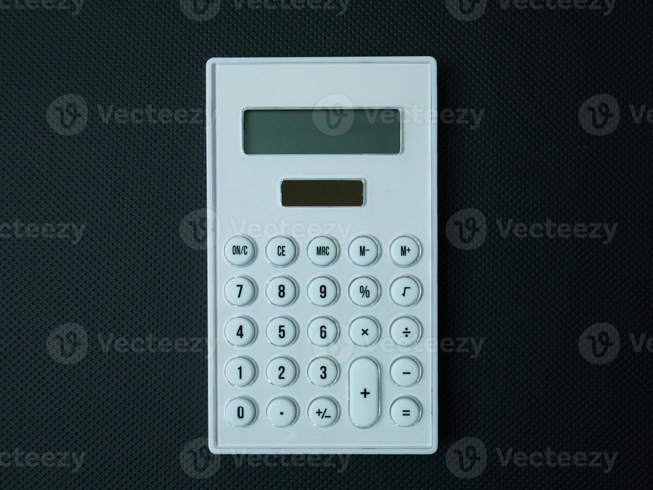 The white calculator on black background for business content. photo