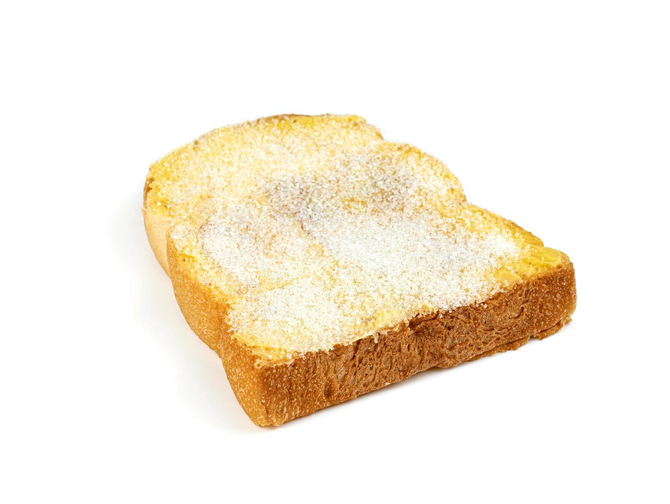 Rebanada de pan tostado con mantequilla y azúcar aislado sobre fondo blanco. foto