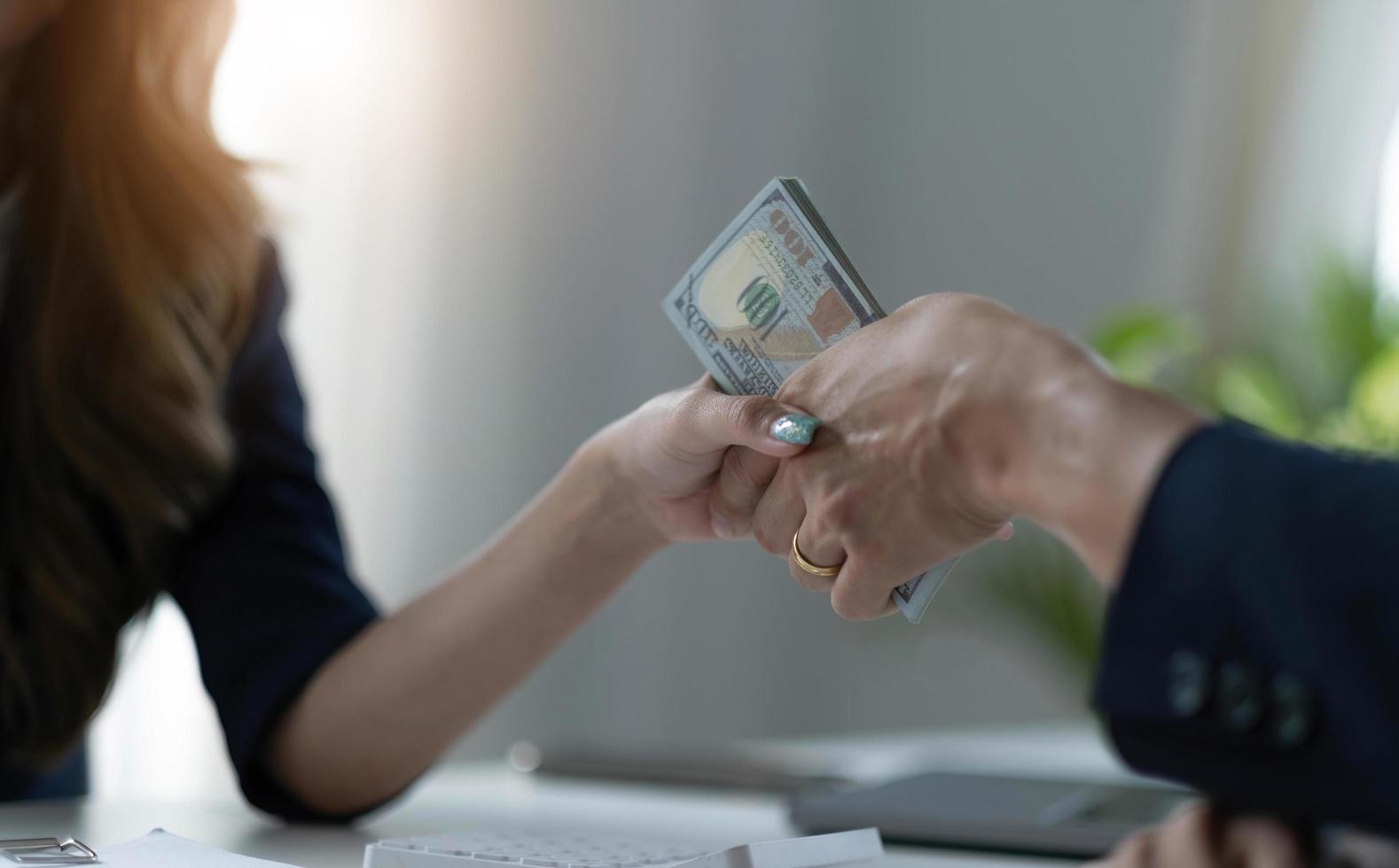 A female lawyer or business legal consultant receives a bribe or tribute from her client in the office. Corruption concept. cropped and close-up image photo