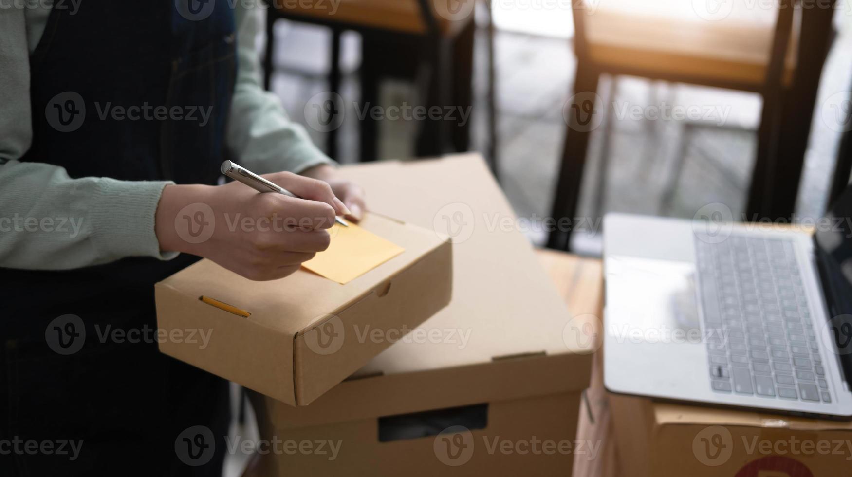 Startup Entrepreneurship Small Business SME Freelance Young lady working at home with boxes and laptop online Marketing Packaging SME Shipping Ecommerce Concepts photo