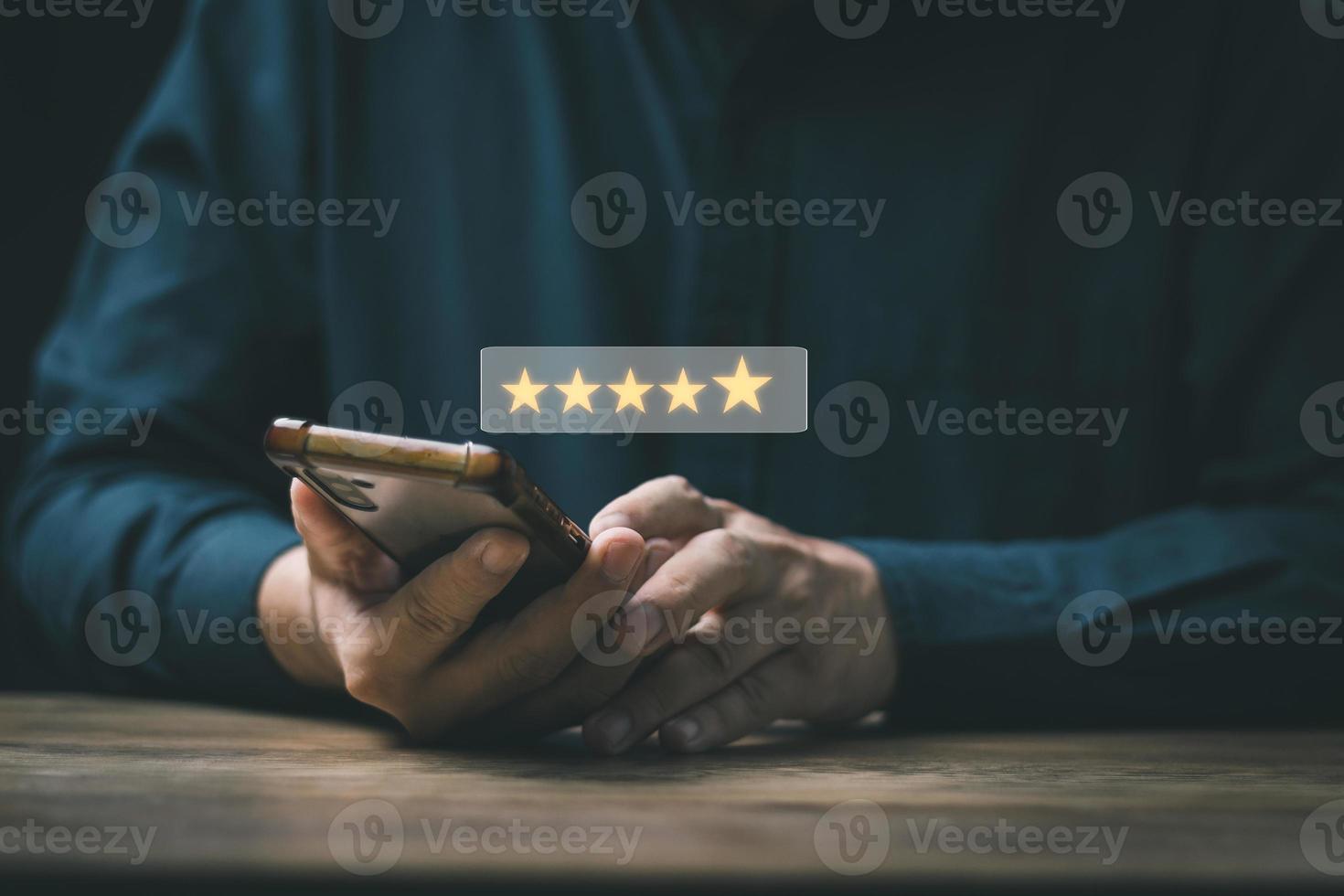 Customer Satisfaction Survey Concept, A man's hand using a smartphone gives a 5 star rating to show the highest level of satisfaction with excellent service.. photo