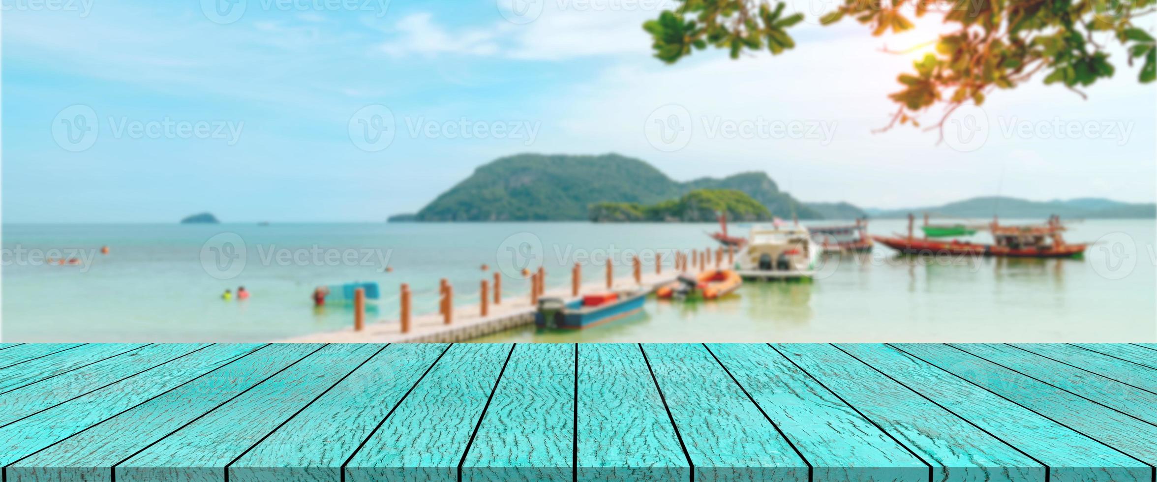 long wooden table with beach landscape blur background photo