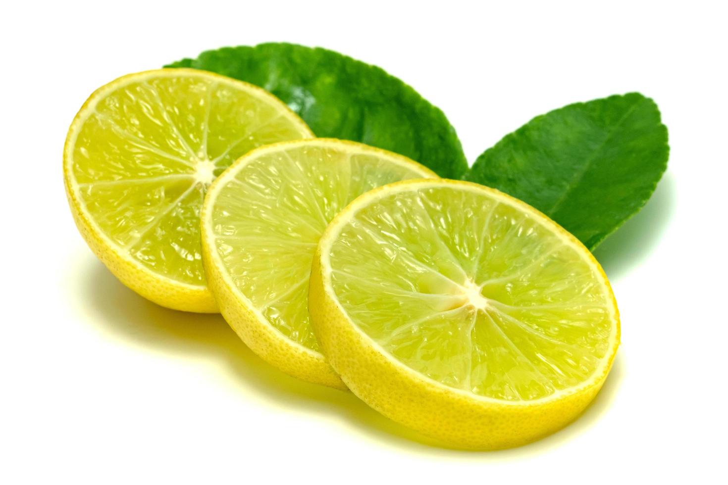 Yellow lemon slice and leaves isolated on white background photo