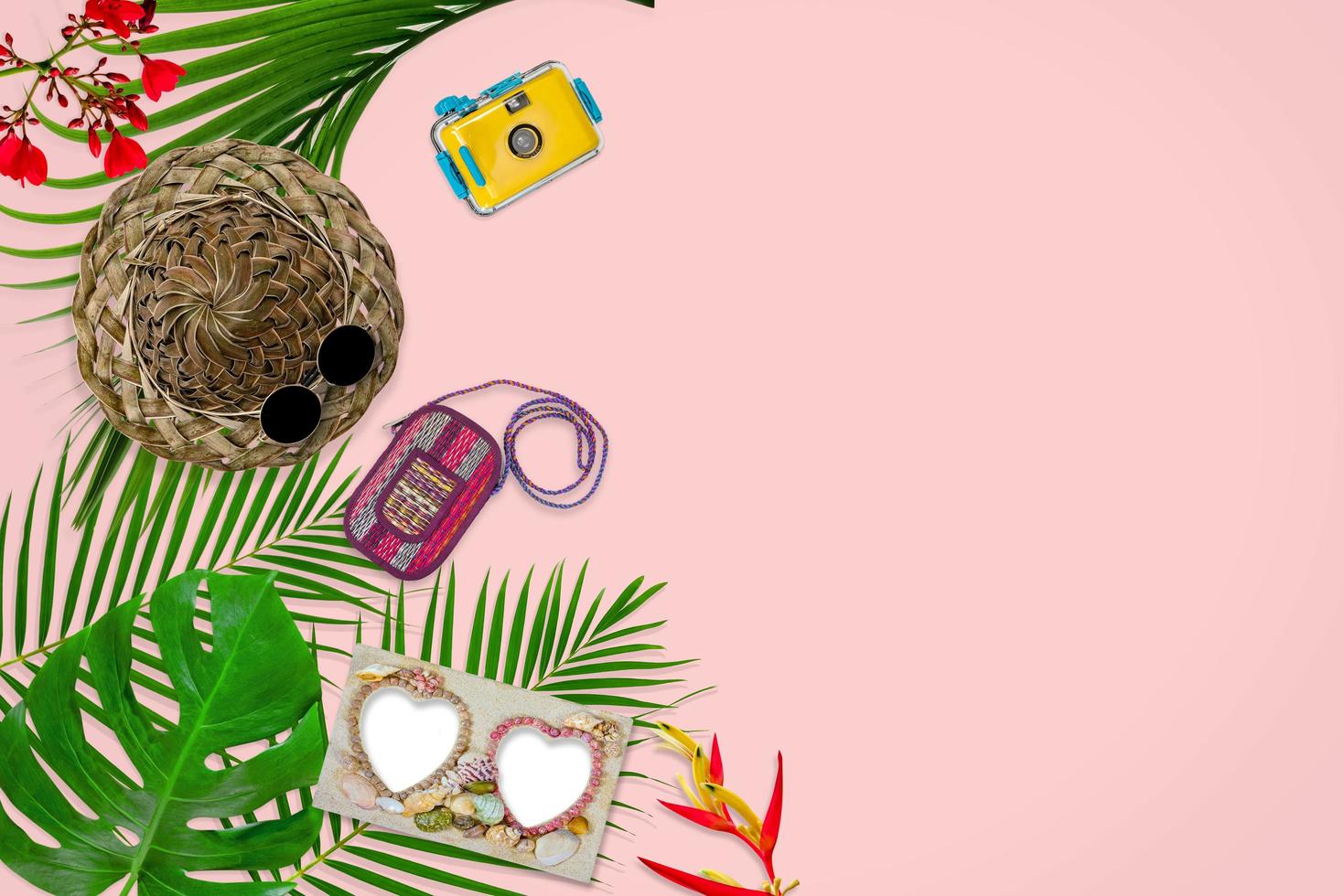 accessories composition for summer concept with tropical palm leaves on pastel pink background, top view and copy space photo