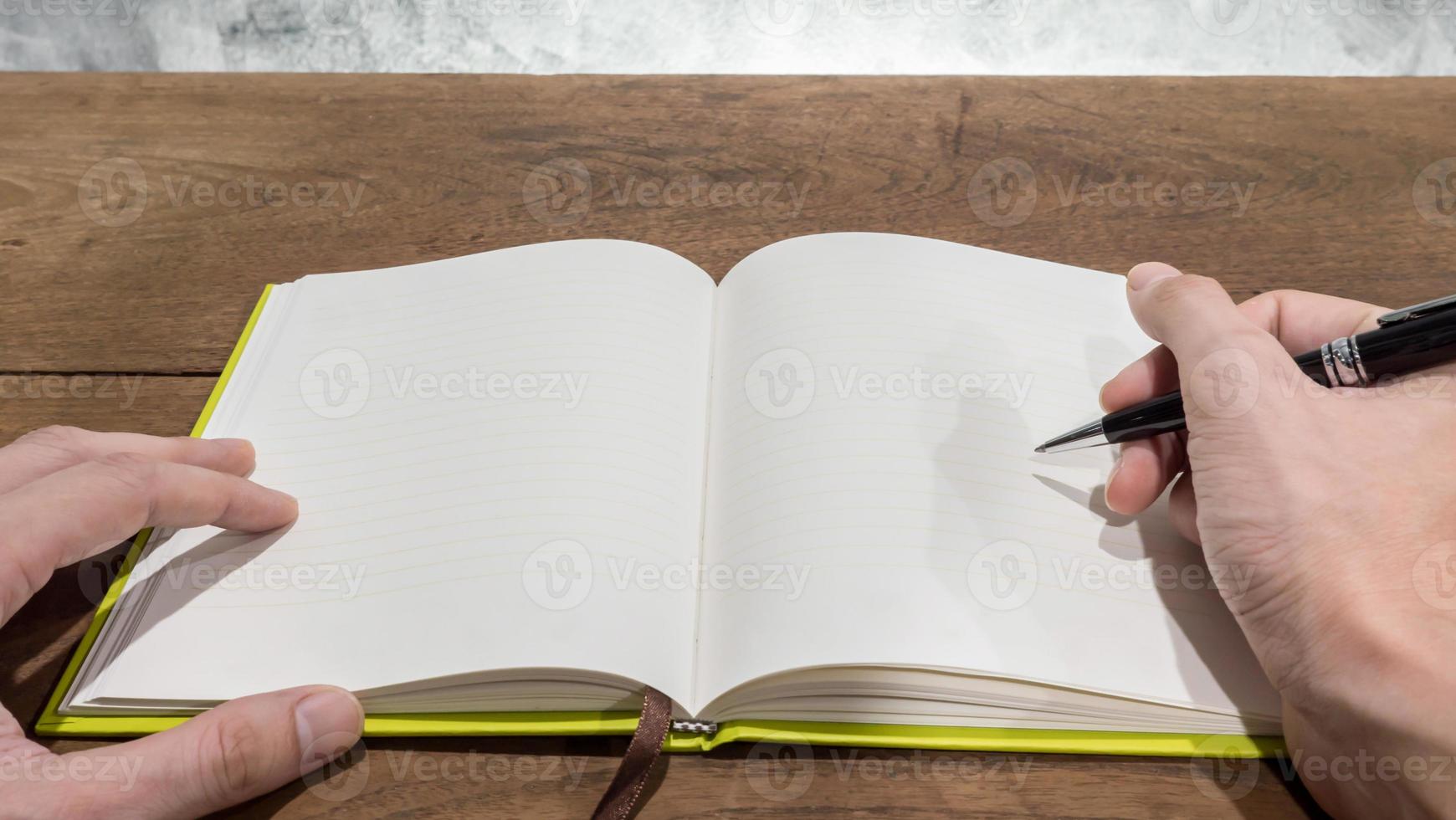 Hands with pen writing on notebook. photo