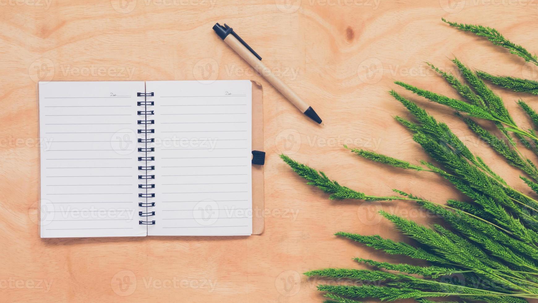 Top view of  blank notebook with whet crop on wooden table background. photo