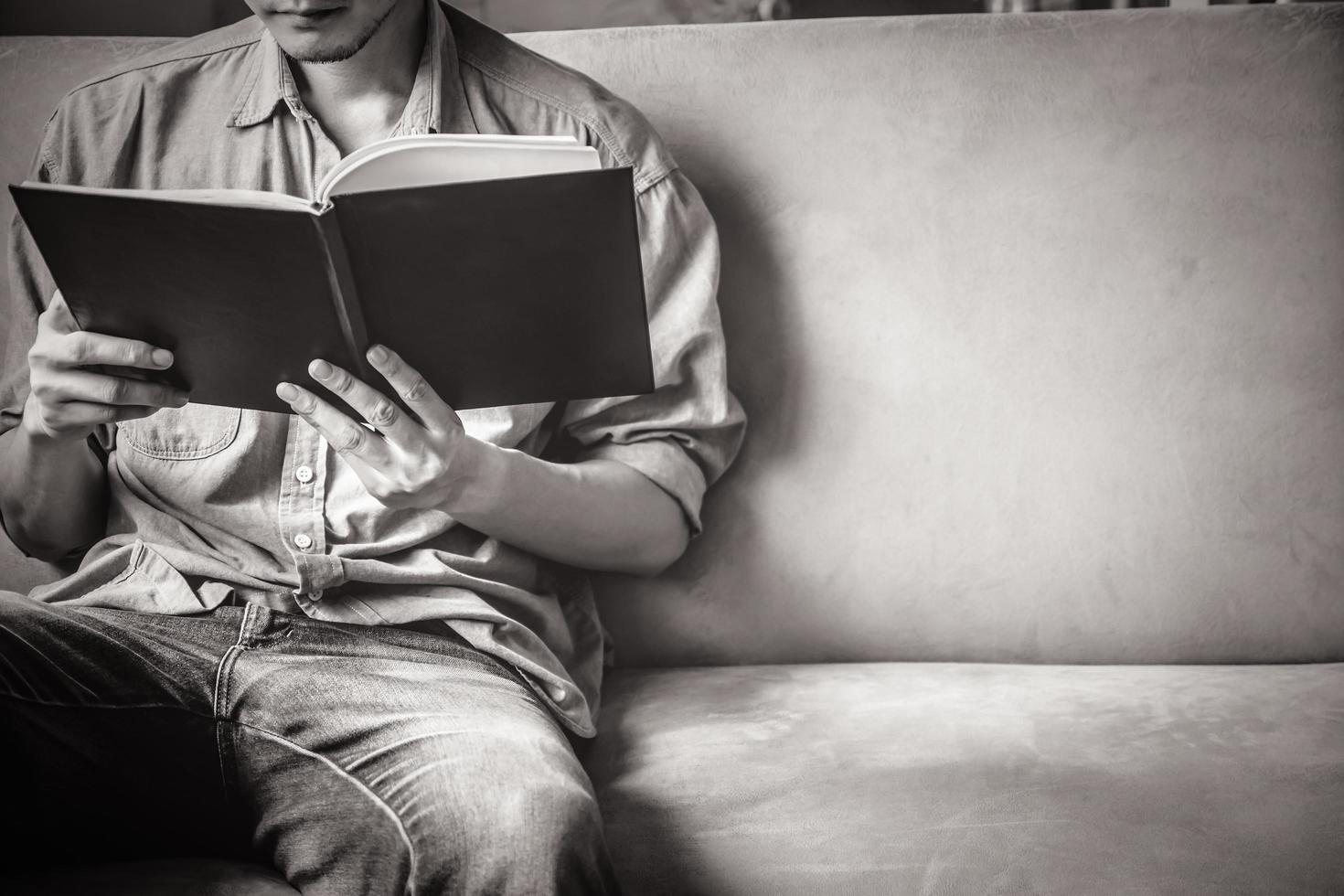 Casual young man reading documents on sofa at home. photo