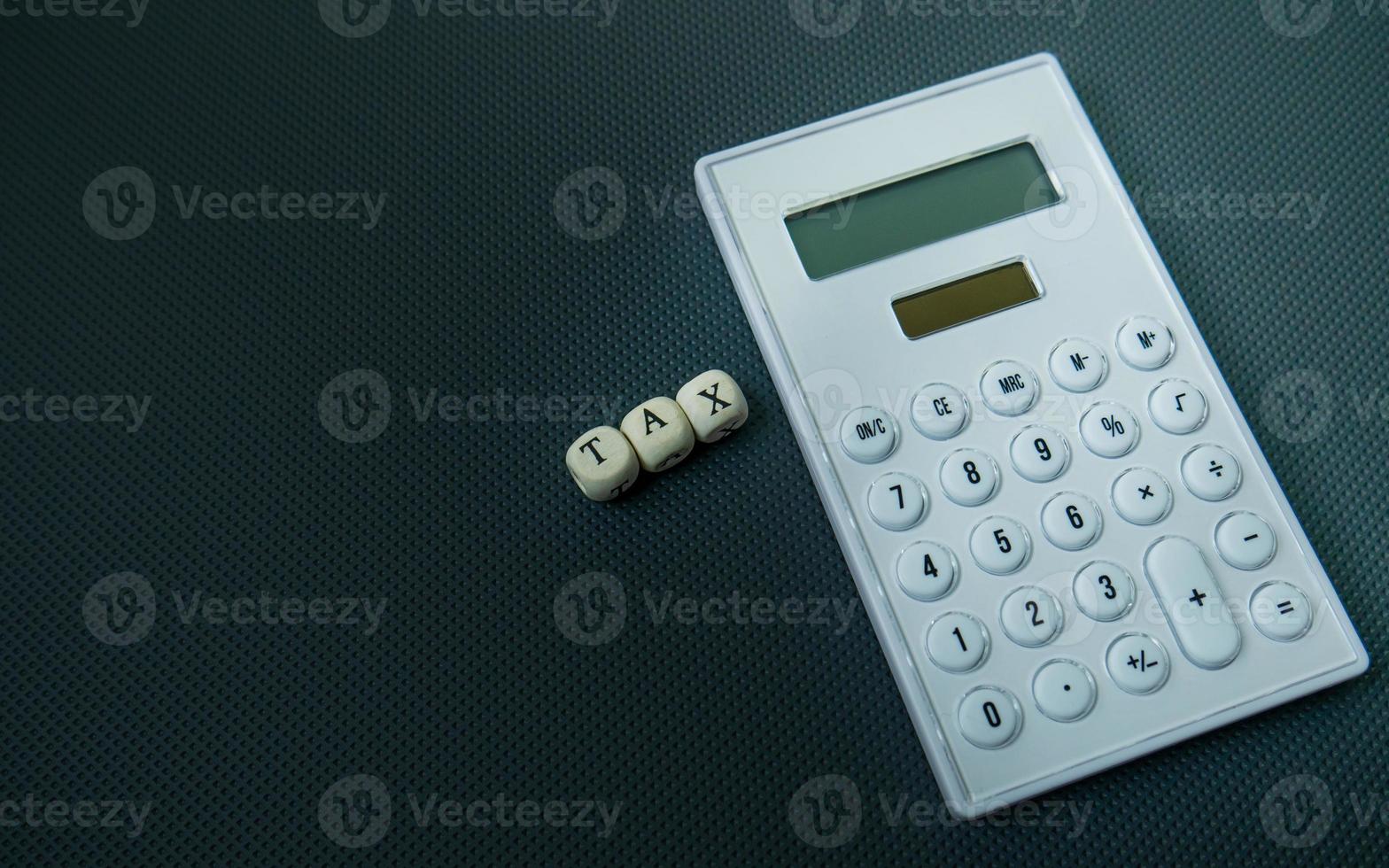 The wood text and calculator on black background for business content photo
