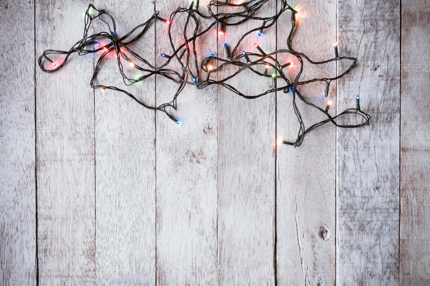 vista superior de las luces de navidad en el fondo de la mesa de madera foto