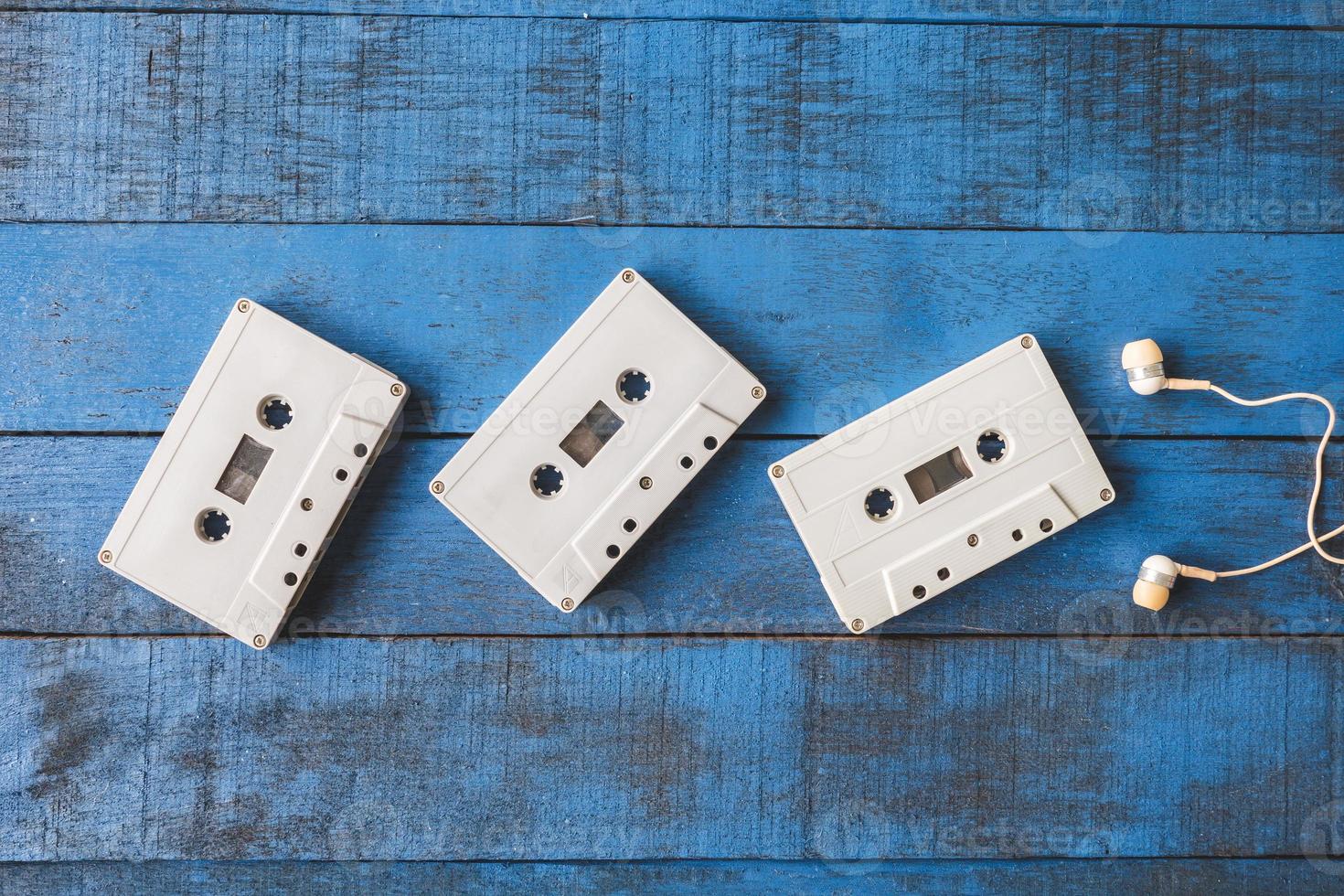 Top view of  Audio tape with earphones on blue wooden table background photo