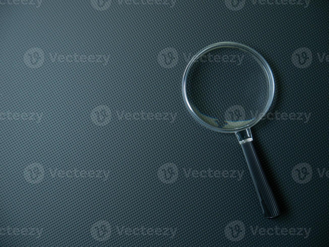 The Magnifying glass on black background for search concept photo